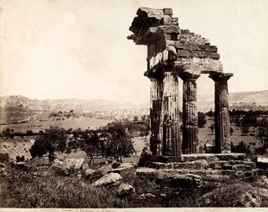View of the remaining four columns supporting an entablature of the Temple of Castor and Pollux in the Valle dei Templi, Agrigento. A panorama of the city is visible in the background